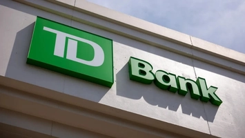 TD Bank exterior signage with bold green TD logo and Bank text displayed on a white branch building wall